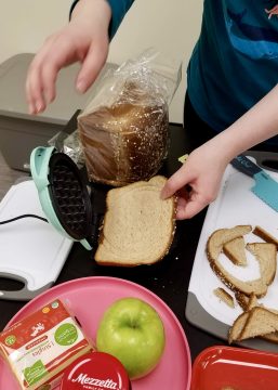 Child putting bread in waffle iron